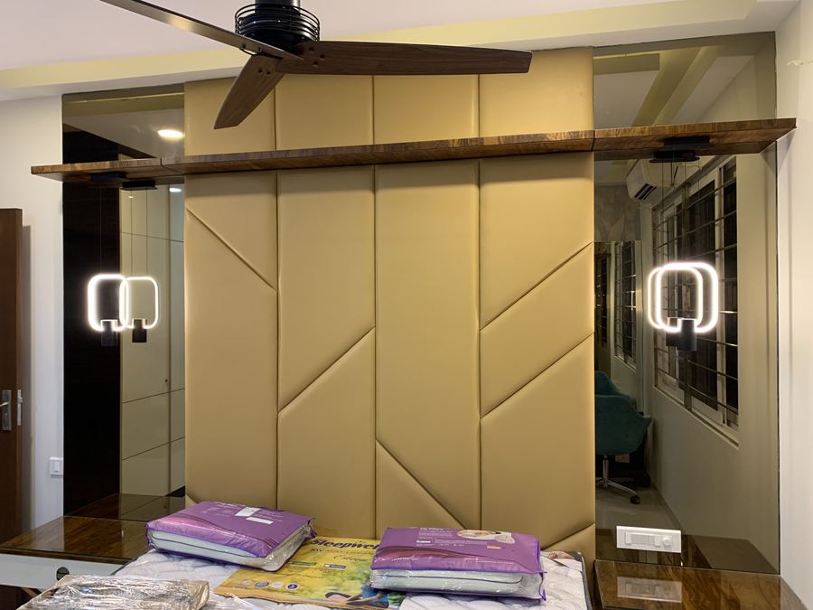 Bedroom wardrobe wall with gold padded panelling and mirror shutters